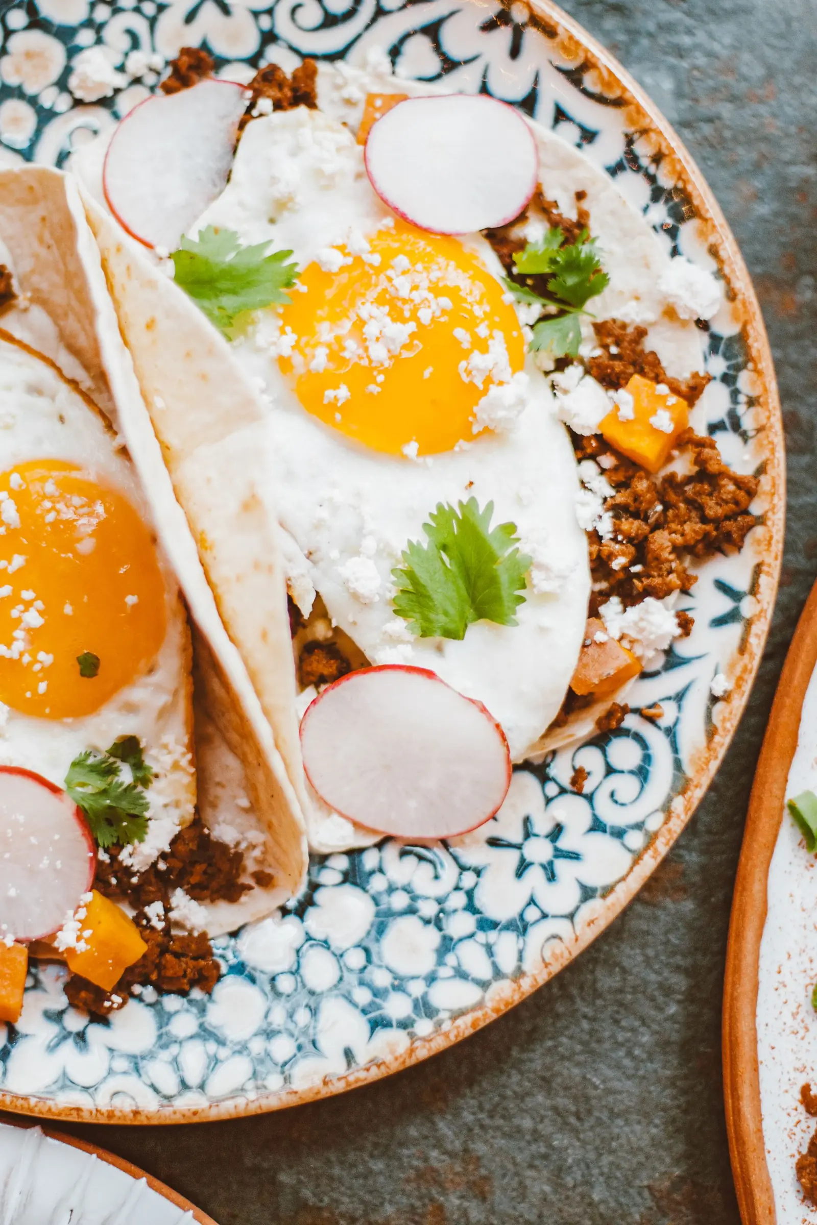 Breakfast tacos with eggs on a plate.